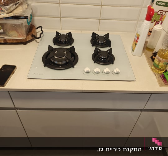 כיריים גז עם ארבעה מבערים וכפתורי שליטה